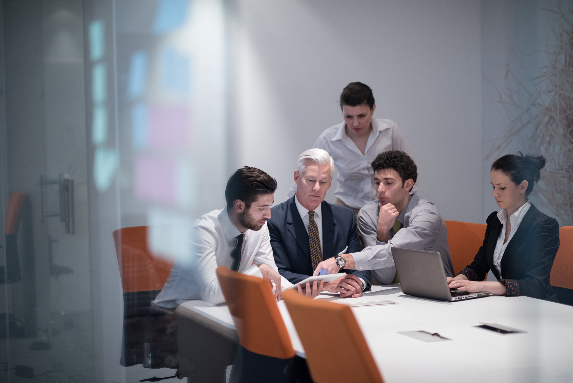 5 people talking at a boardroom table