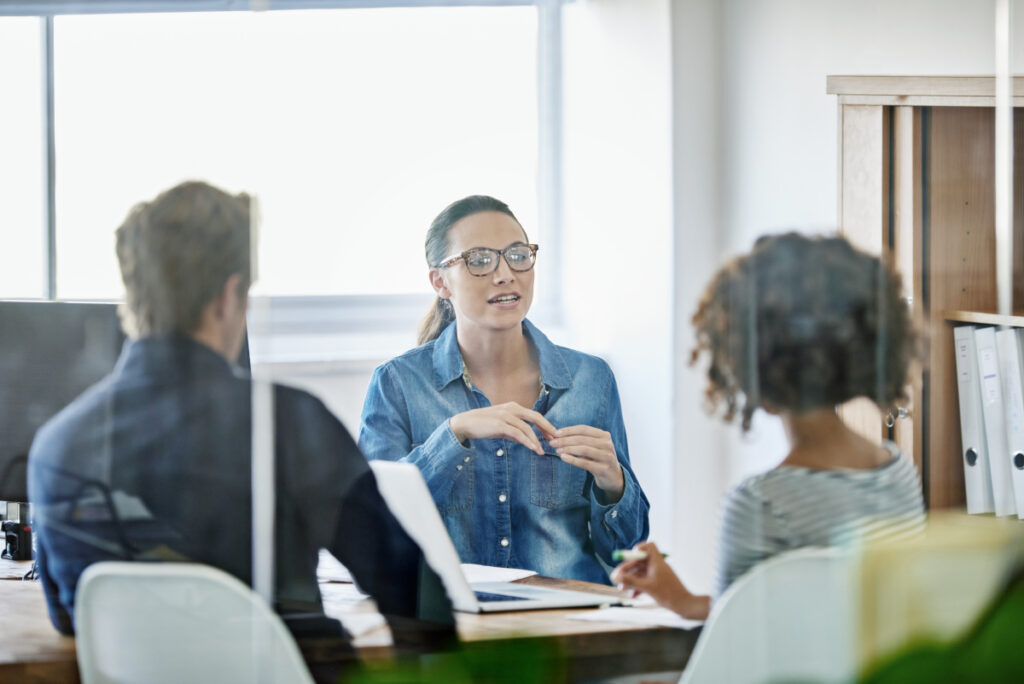 advisor talking to two people from the other side of their desk