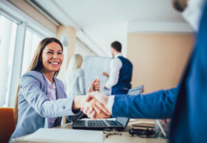 Woman shaking hands with man in blue suit