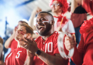 Football fans cheering wearing red