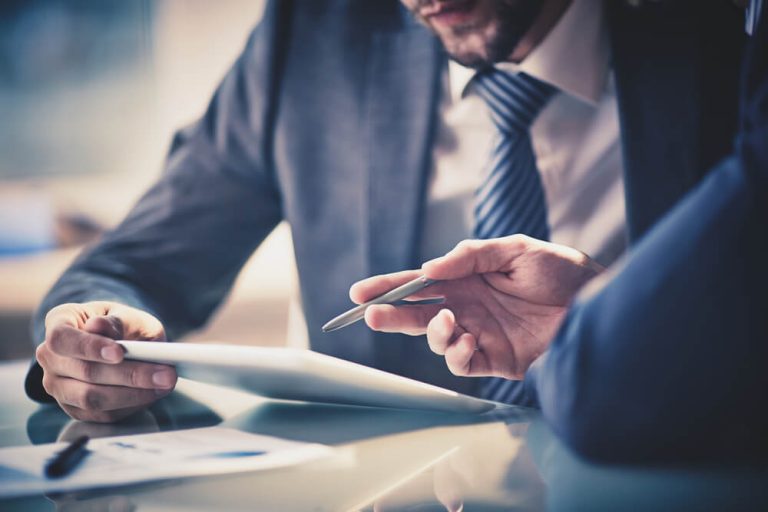 Investors looking at data at business meeting close up