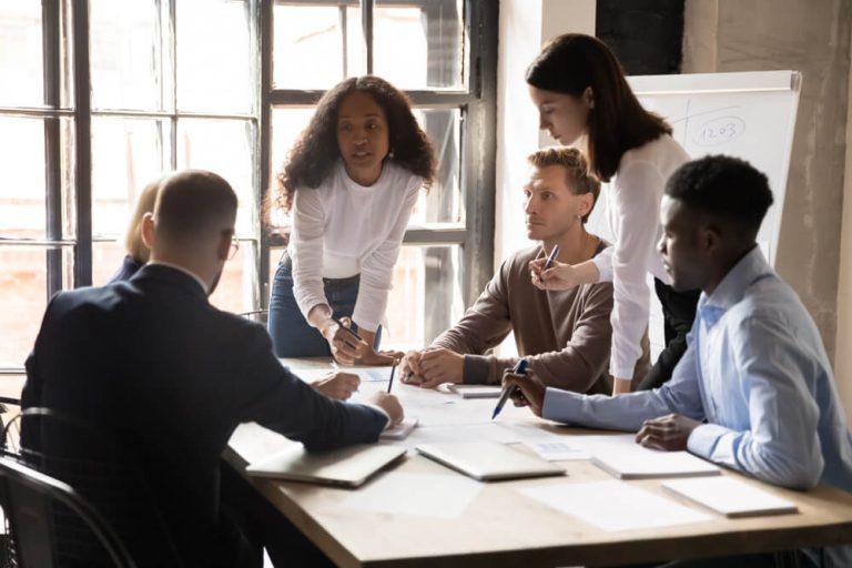 Team of analysts at meeting table discussing data