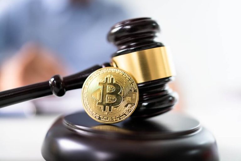 judge's gavel sitting next to bitcoin