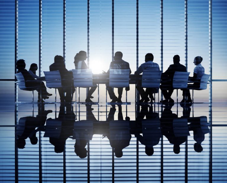 silhouette of table and businessmen sitting at formal meeting