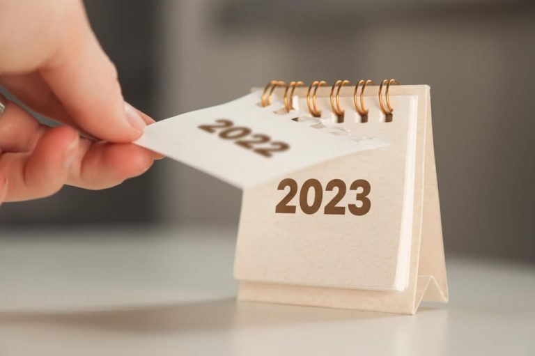 hand flipping 2022 calendar to 2023