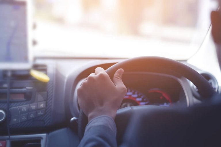 Photo of man driving uber taxi taken from backseat