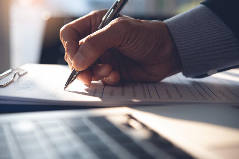 close up on businessman's hand signing agreement