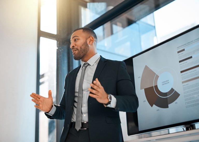 Shot of a young businessman presenting data on a screen during a meeting in an office