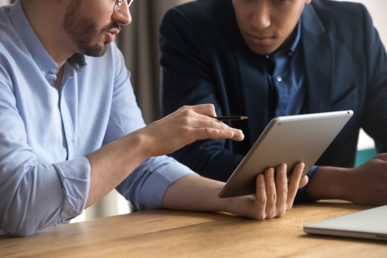 two men meeting looking at iPad