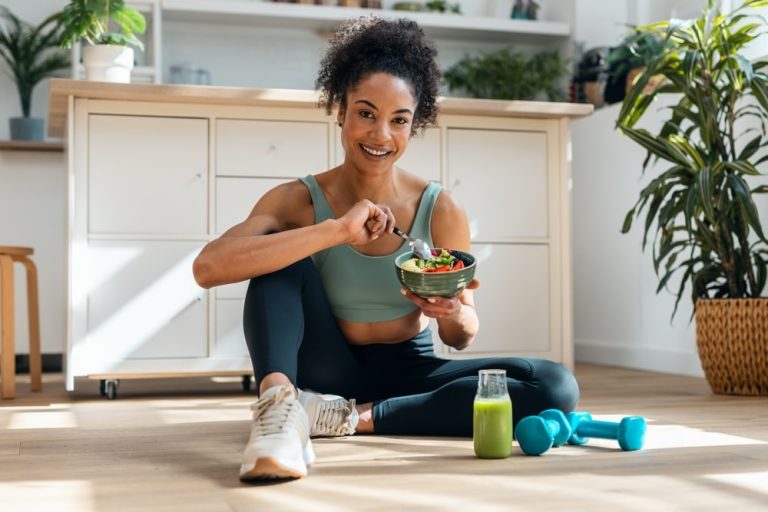 woman sitting on floor eating healthy