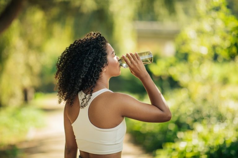 active woman drinking out of water bottle health and wellness